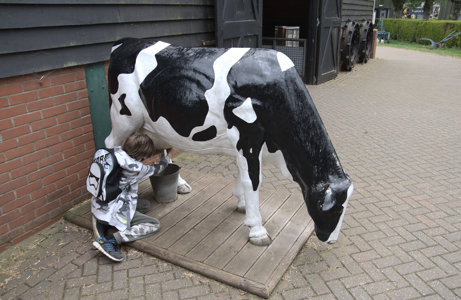 Harry has a go at milking a cow from A Moth Infestation and a Trip to the Zoo, Banham, Norfolk - 21st May 2022
