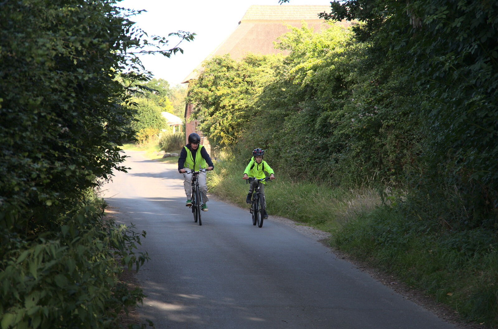 Isobel and Harry cycle down the lane from the pub from Camping in the Dunes, Waxham Sands, Norfolk - 9th July 2022