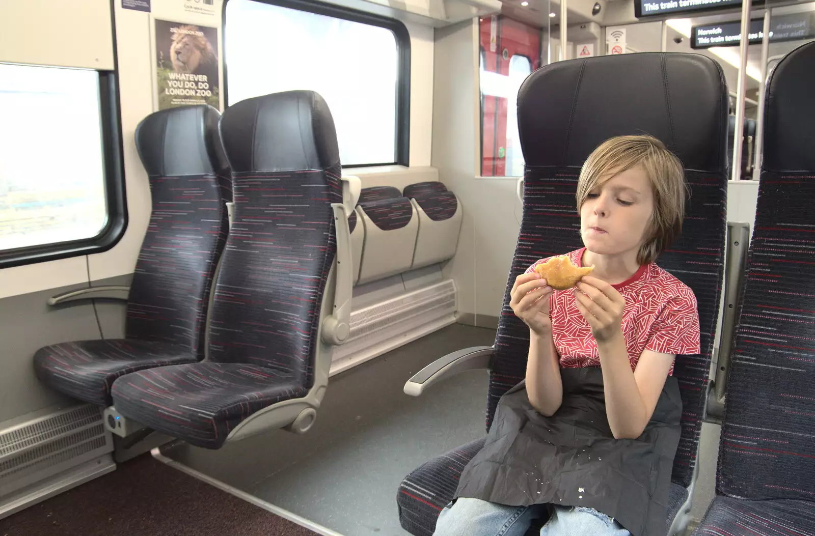 Harry scoffs a doughnut on the train, from A July Miscellany, Diss, Eye and Norwich - 23rd July 2022