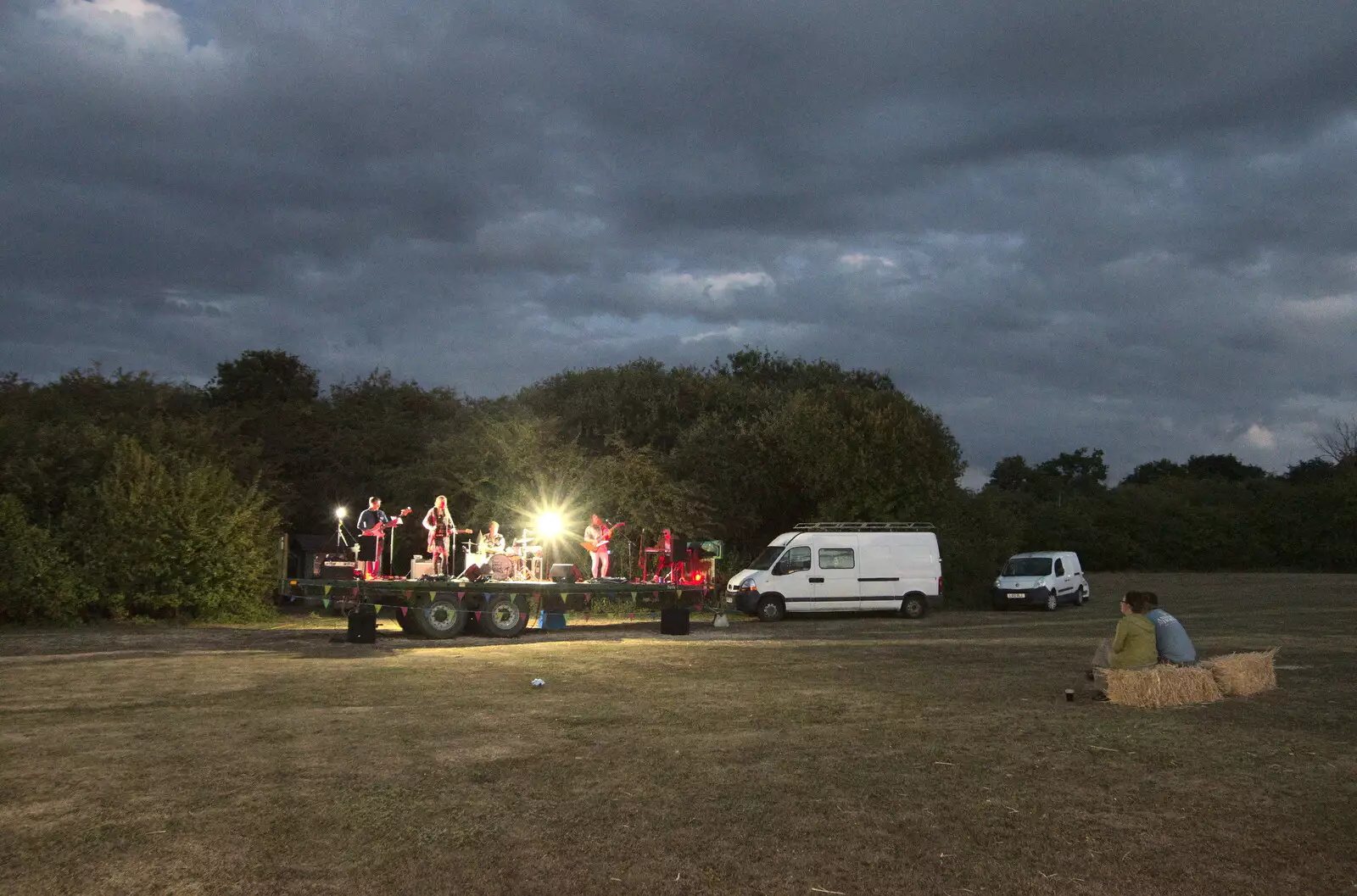 Suey and Marc watch the band from a straw bale, from Little Red Kings at Fly High Festival, Seething Airfield, Norfolk - 5th August 2022