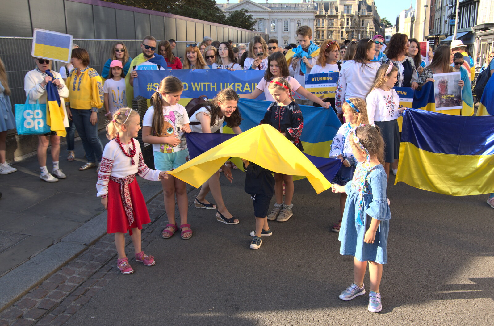 There's a small child under a flag from Anglesey Abbey and a #StandWithUkraine Demo, Cambridge - 24th August 2022