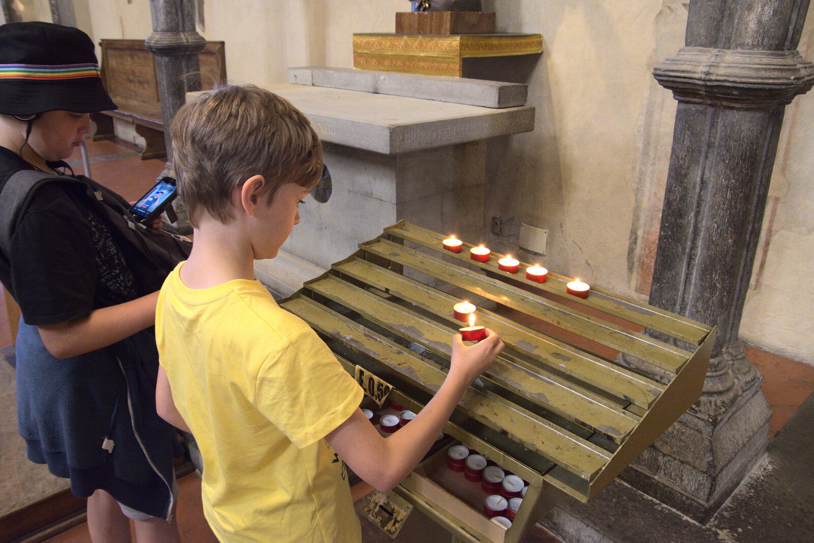 The Flags of Arezzo, Tuscany, Italy - 28th August 2022: Harry lights a votive candle