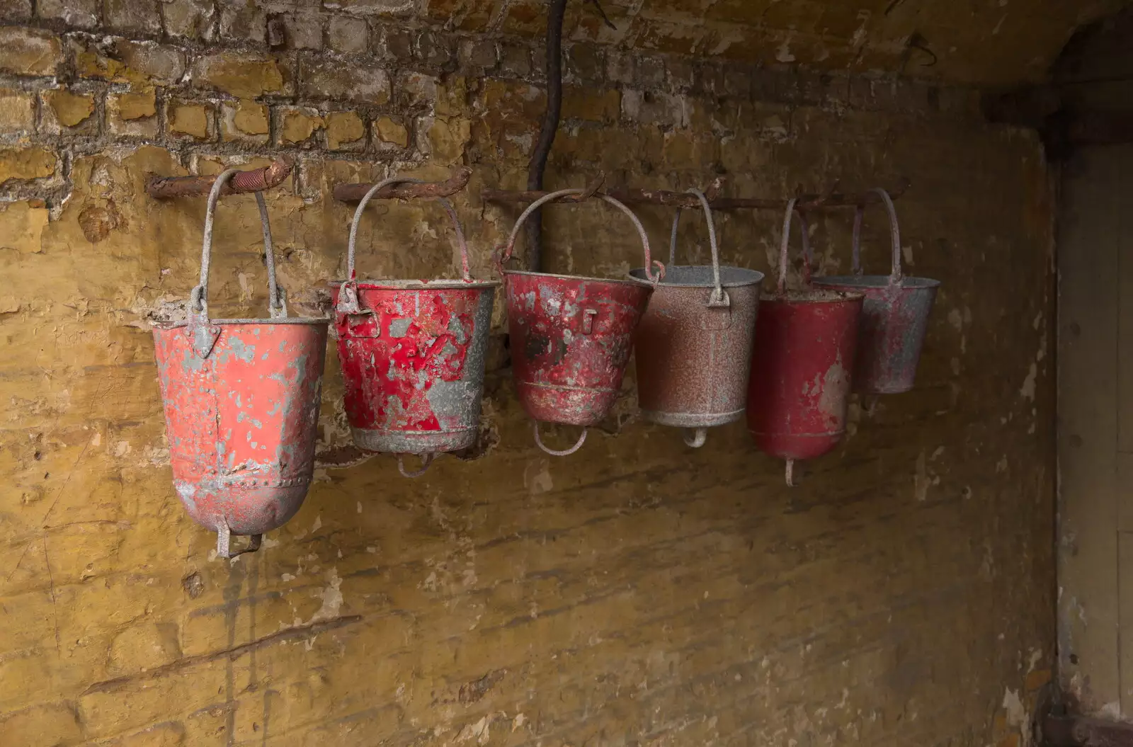 Red fire buckets line up on a yellow wall, from A Trip to Landguard Fort, Felixstowe, Suffolk - 16th October 2022