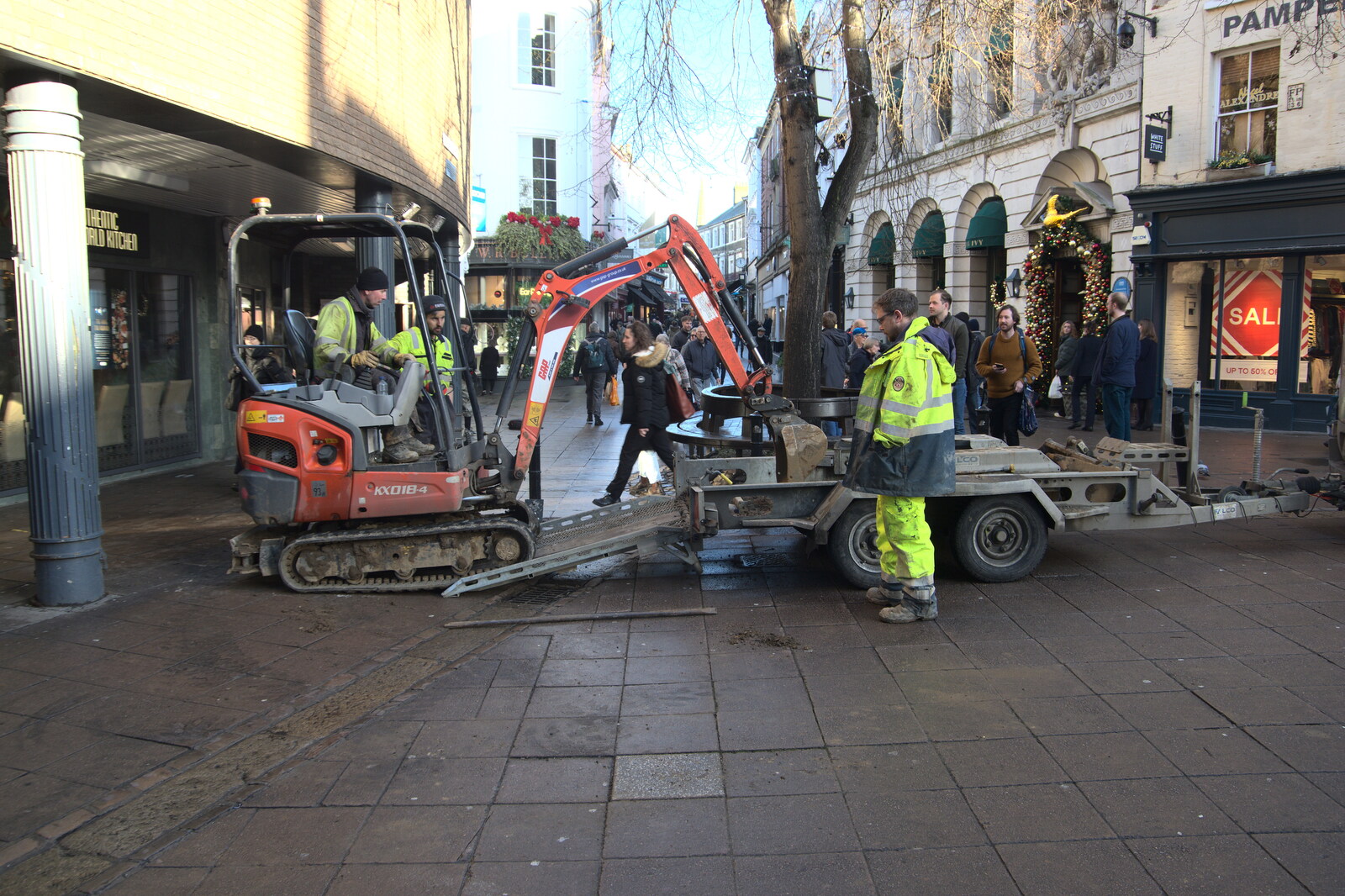A digger hauls itself up after shedding a track from Christmas Shopping in Norwich, Norfolk - 21st December 2022