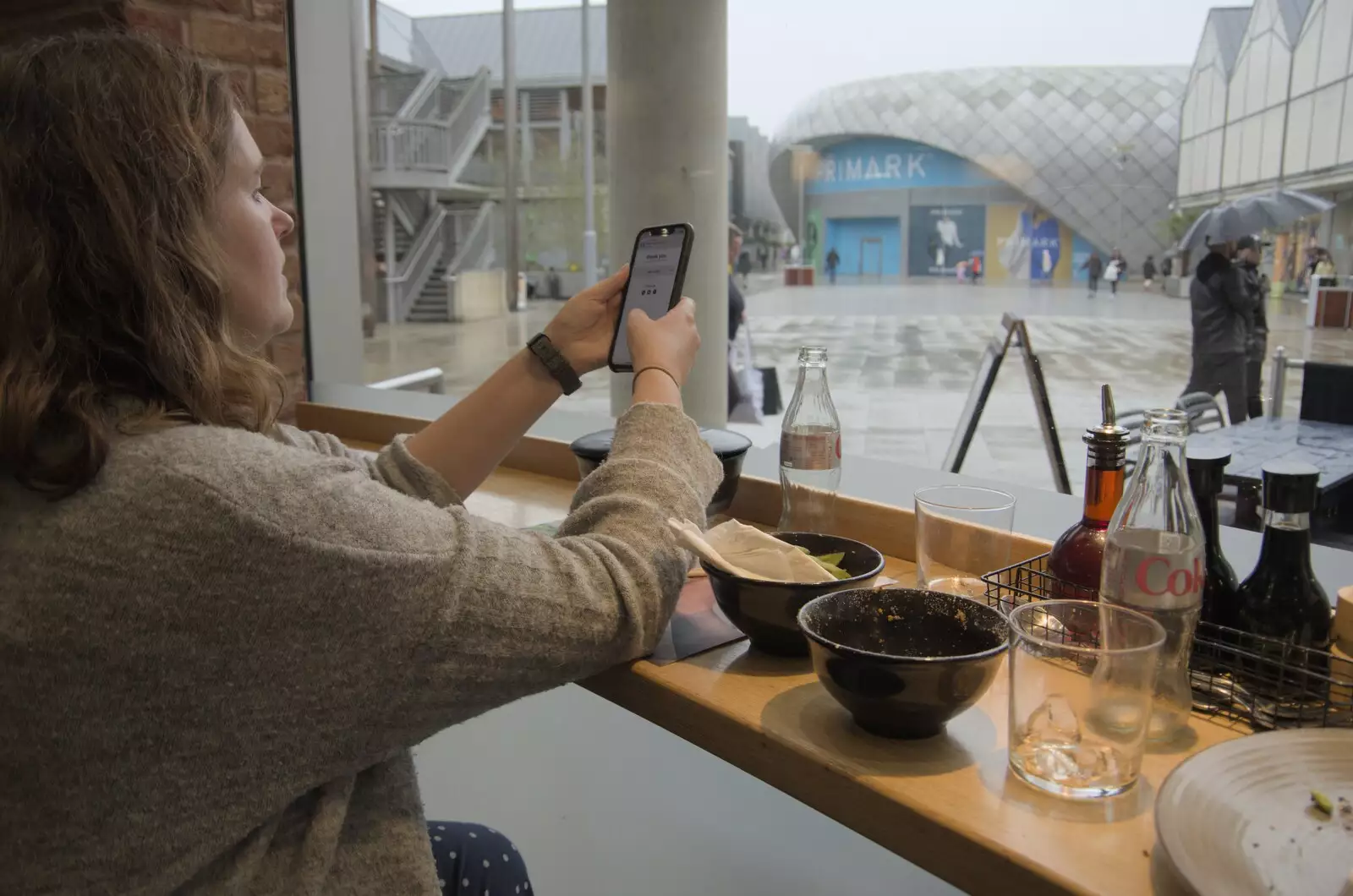 Isobel pays the Wagamama bill with her phone, from Tales From The Floods, Bury St. Edmunds and Walsham Le Willows, Suffolk - 20th October 2023