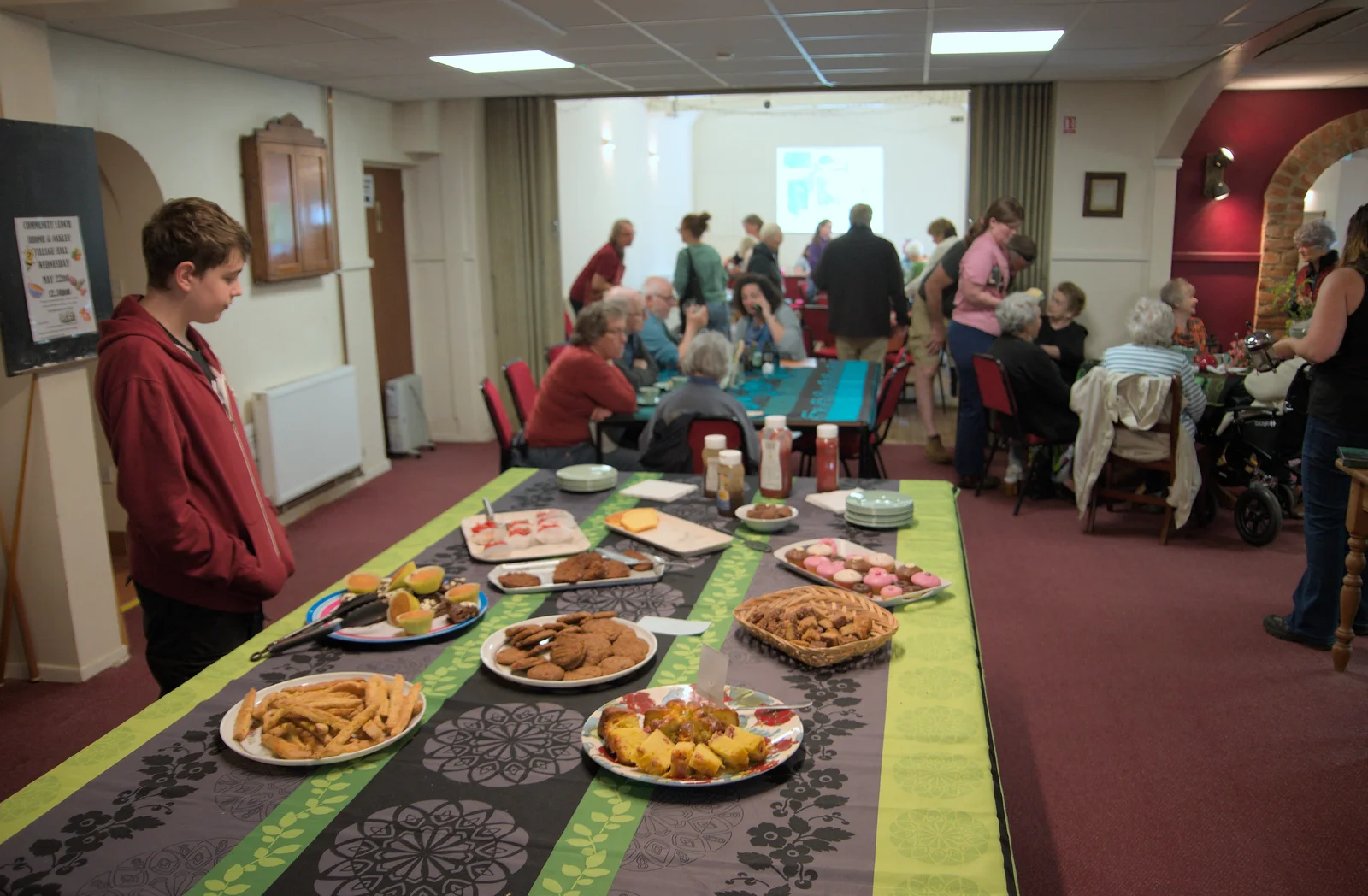 Fred inspects the table of food in the village hall, from The Village Hall Plant Sale, and a New Dinghy, Weybread, Norfolk - 19th May 2024