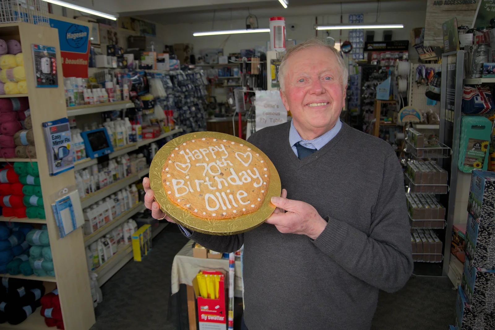 Ollie holds up his birthday biscuit in the shop, from Ollie's 70th Birthday, The Handyman, Eye, Suffolk - 1st June 2024