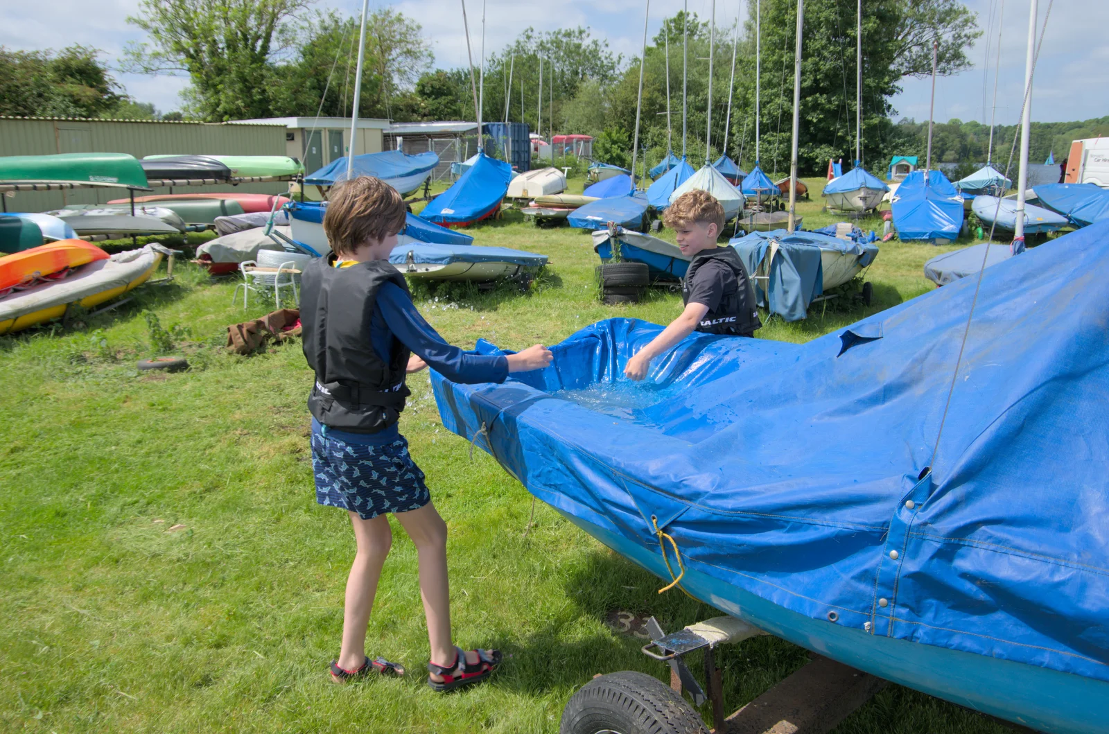 Harry and his friend Christopher scoop water out, from Sailing at the Lake, and the GSB at Mellis, Suffolk - 6th June 2024