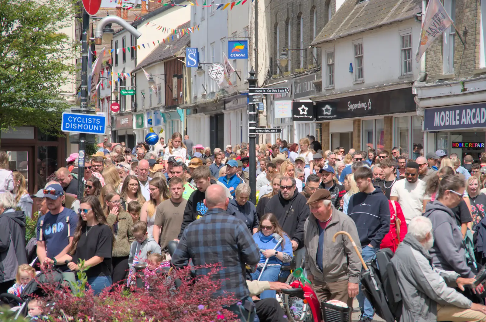 Crowds follow the end of the parade down Mere Street, from The Carnival Procession, Diss, Norfolk - 16th June 2024