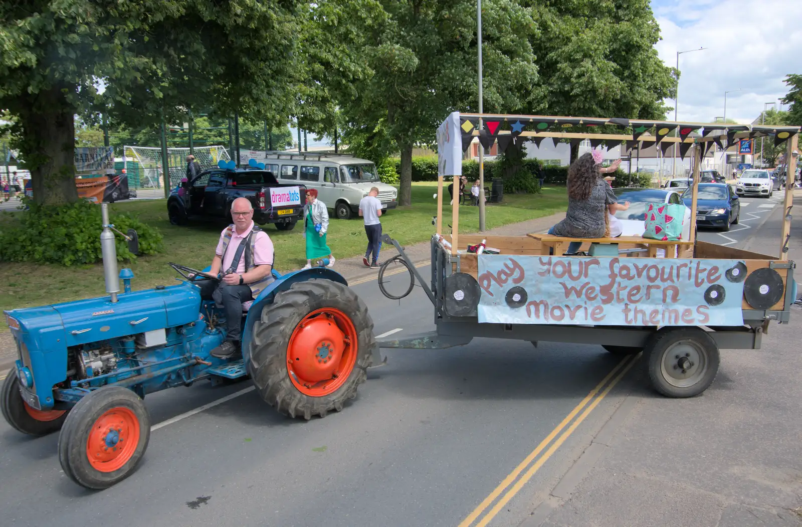 The Fordson tractor pulls out of the bus station, from The Carnival Procession, Diss, Norfolk - 16th June 2024