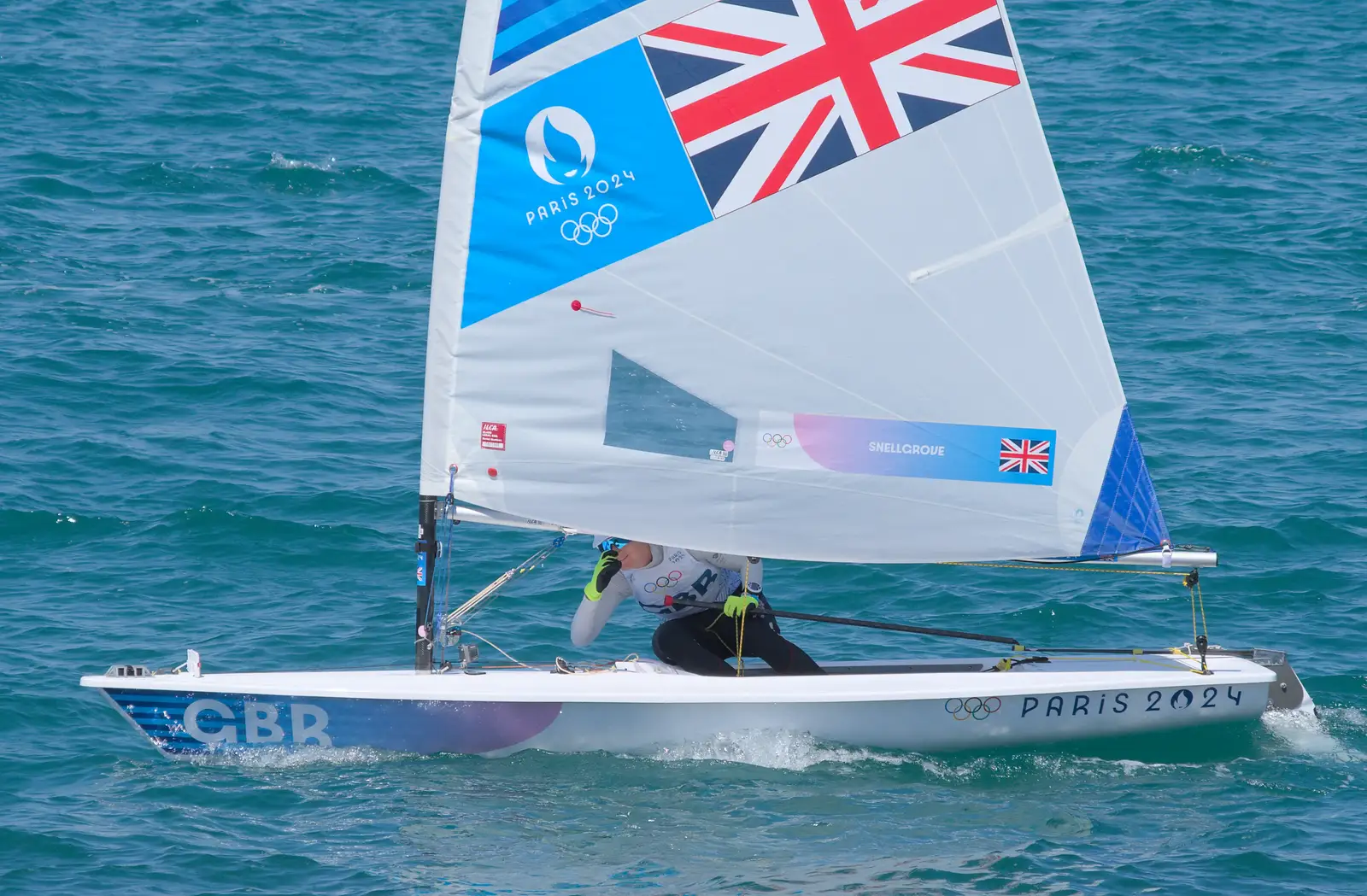 Hannah peers out from under the boom, from Hannah and Olympic ILCA 6 Sailing, Marseille, France - 5th August 2024