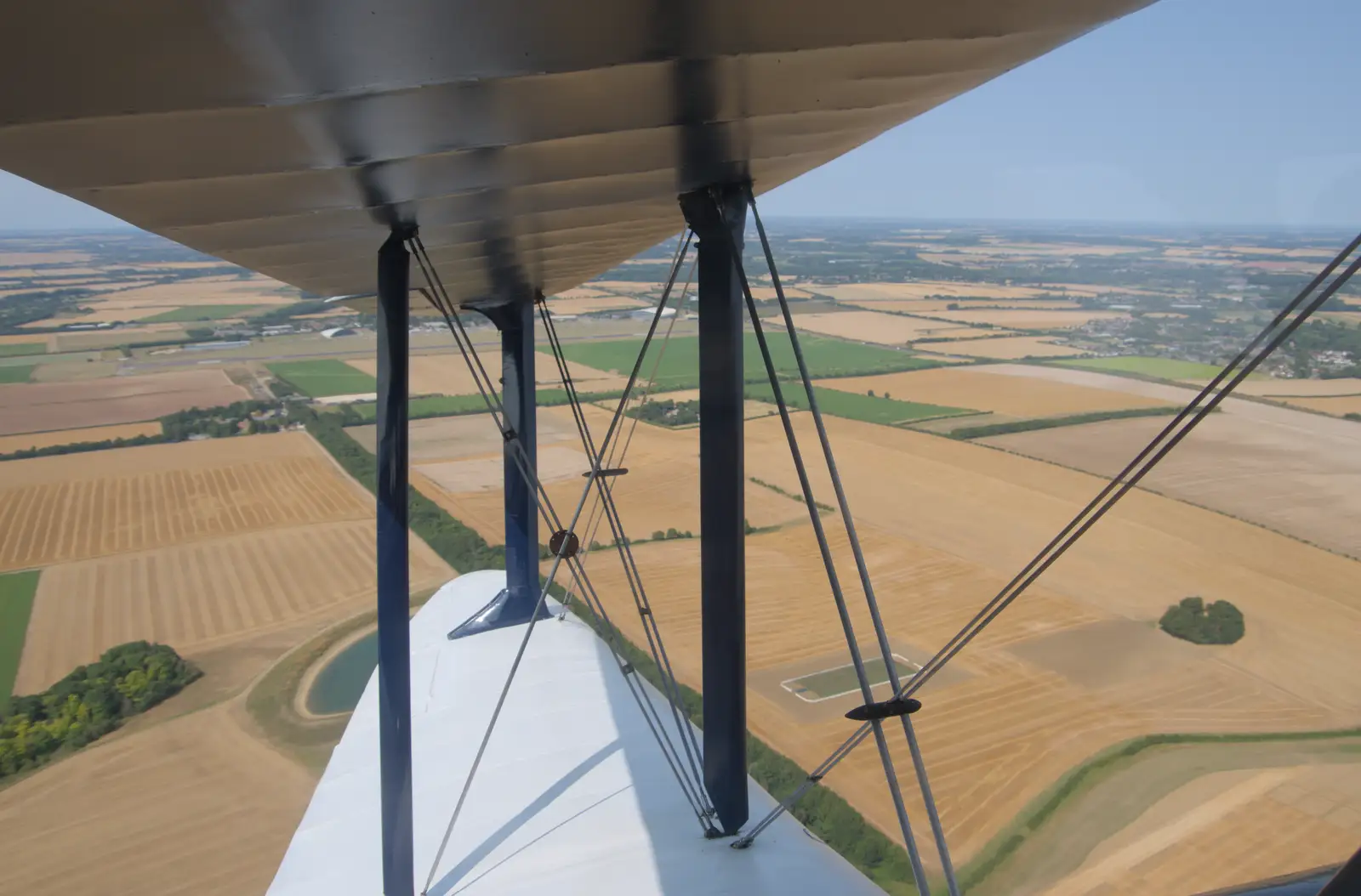 Cambridge fields through the wings of a biplane, from Flying in a Dragon Rapide, IWM Duxford, Cambridgeshire - 17th August 2024