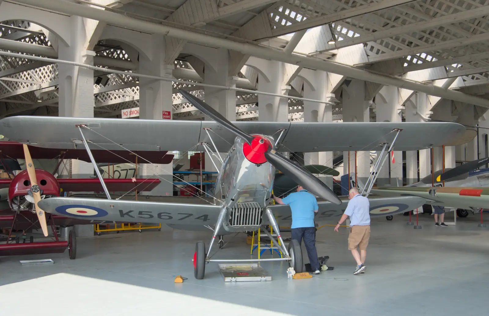 A biplane is worked on, from Flying in a Dragon Rapide, IWM Duxford, Cambridgeshire - 17th August 2024