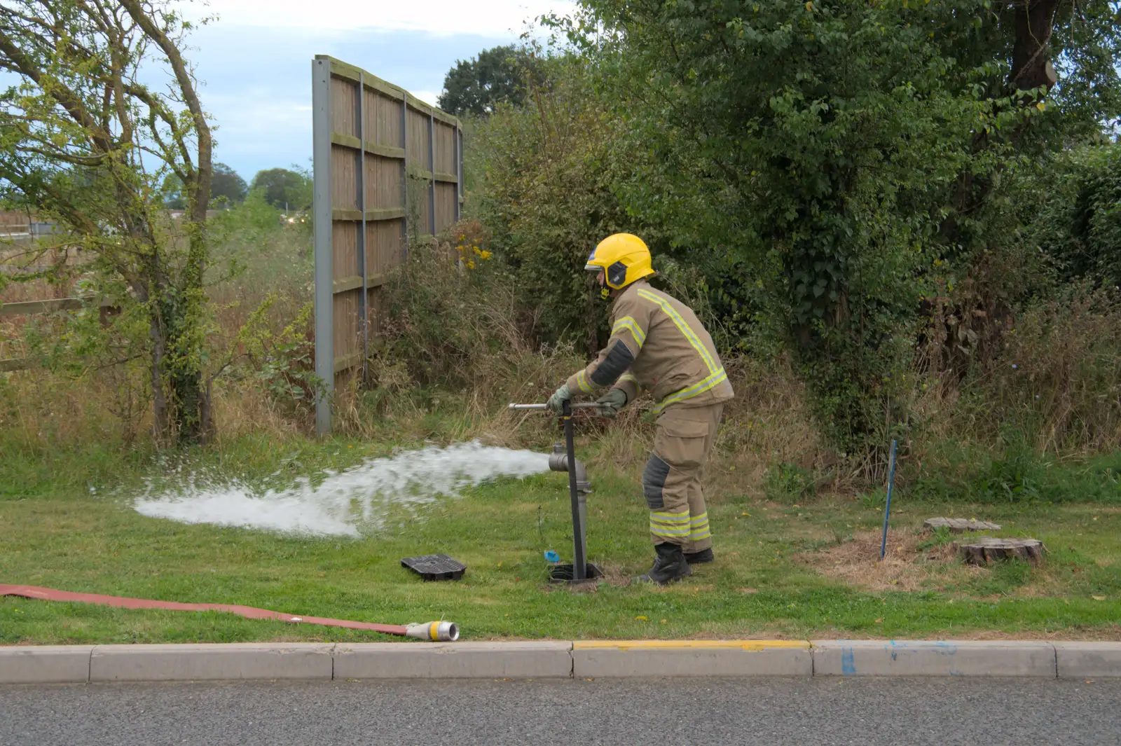 A firefighter taps a fire hydrant, from A Major Fire at Suffolk Highways, Brome, Suffolk - 15th September 2024