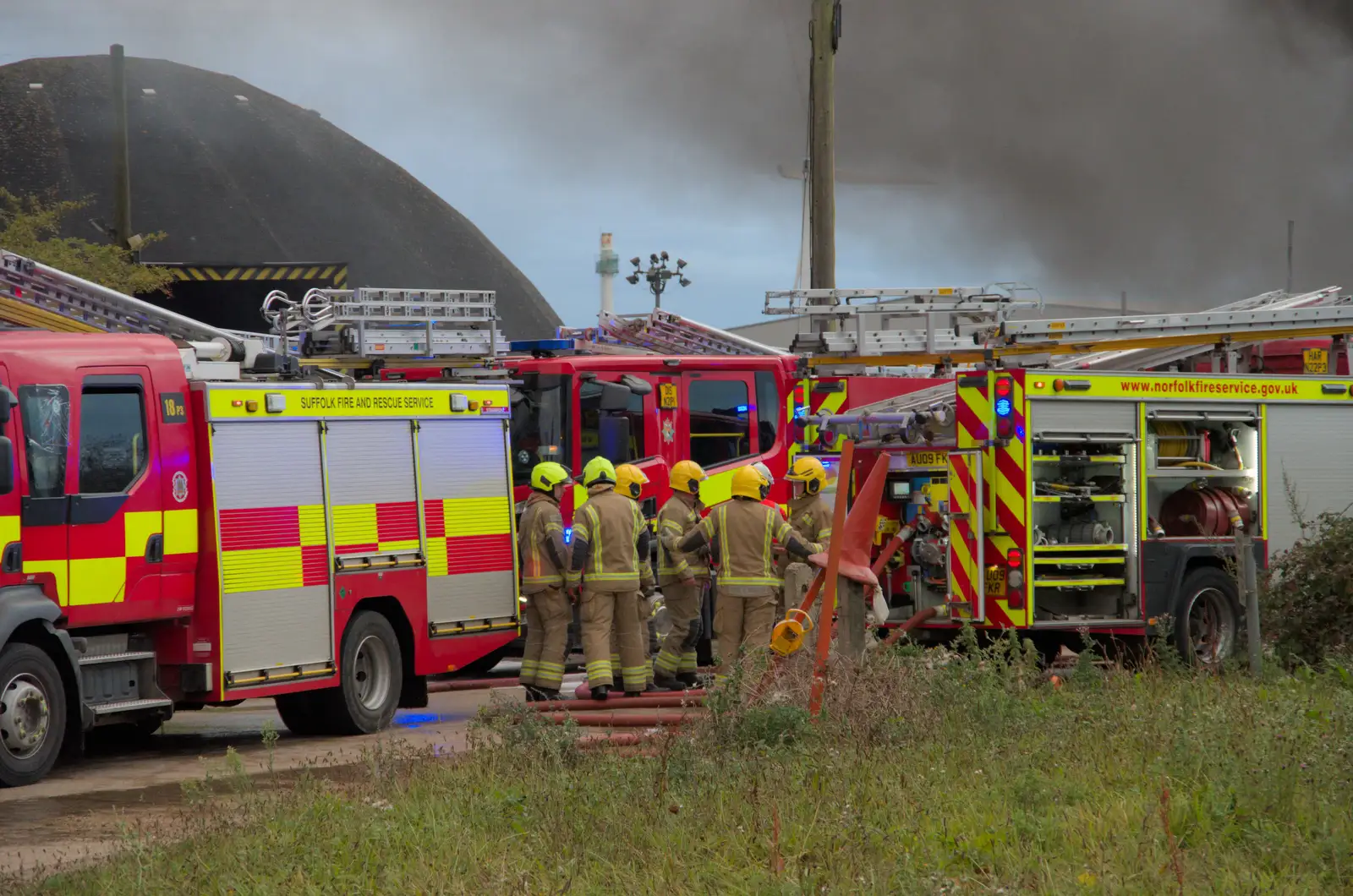 There's some sort of fire-fighter huddle, from A Major Fire at Suffolk Highways, Brome, Suffolk - 15th September 2024