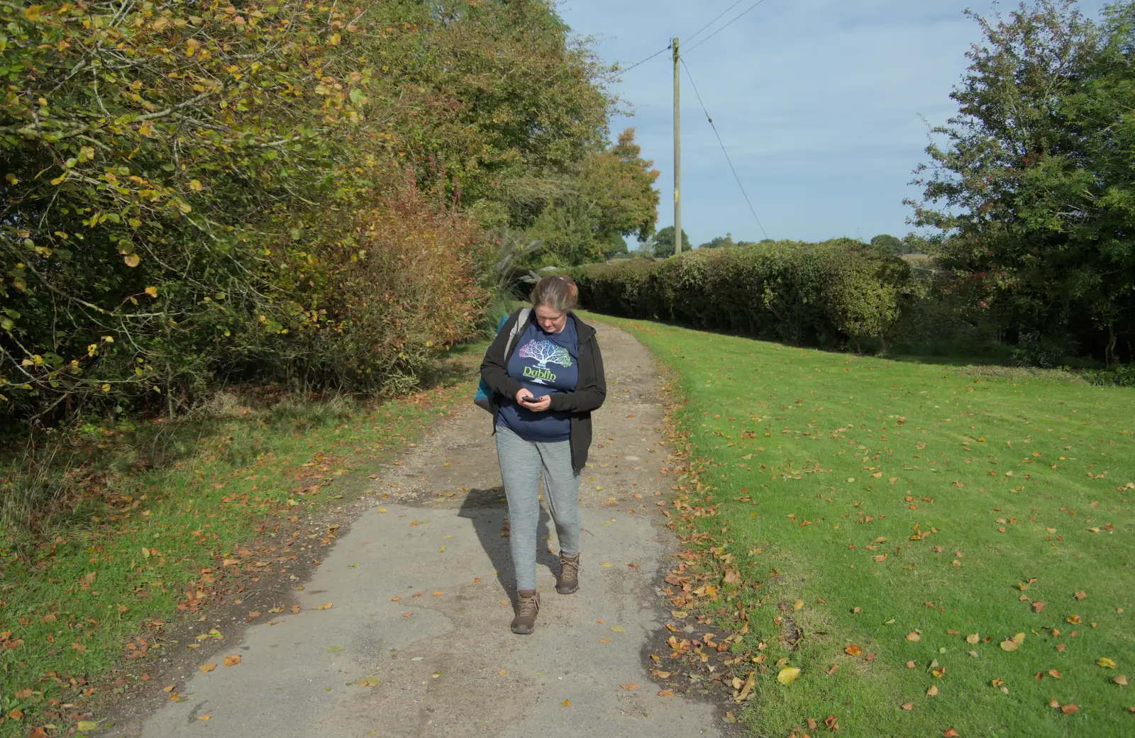 Isobel checks her phone, from A Walk to the Railway Tavern, Mellis, Suffolk - 13th October 2024