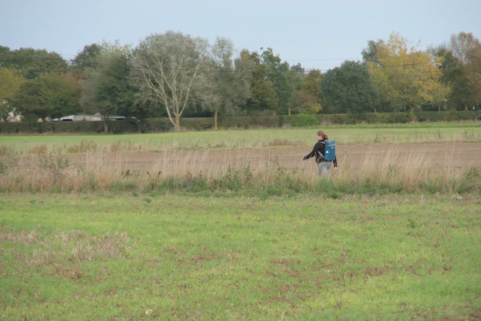 Isobel strides off up the road, from A Walk to the Railway Tavern, Mellis, Suffolk - 13th October 2024