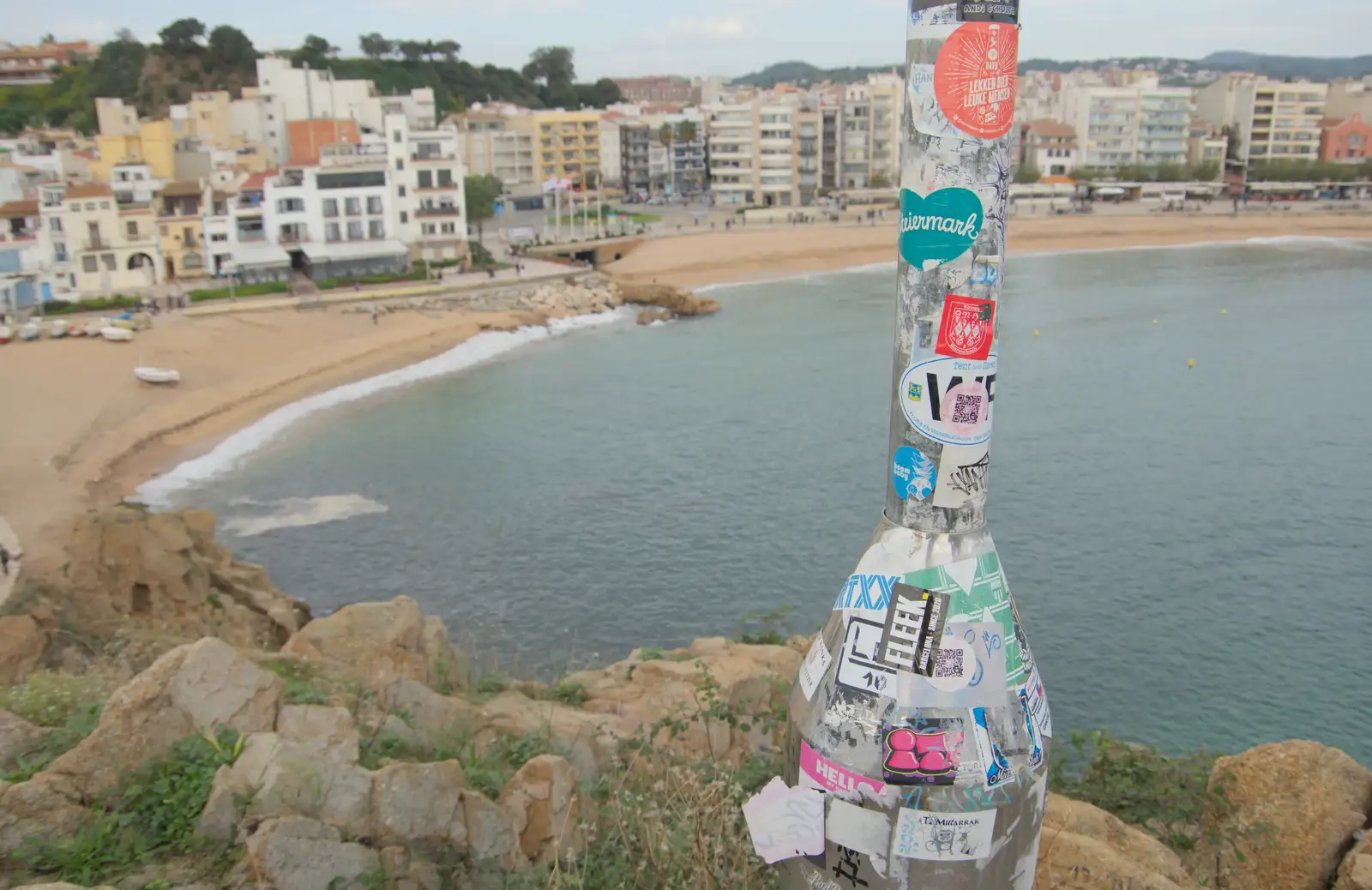 A lampost on a hill with a lot of stickers, from Blanes, and the Castanyada Festival, Lloret de Mar, Catalunya - 1st November 2024