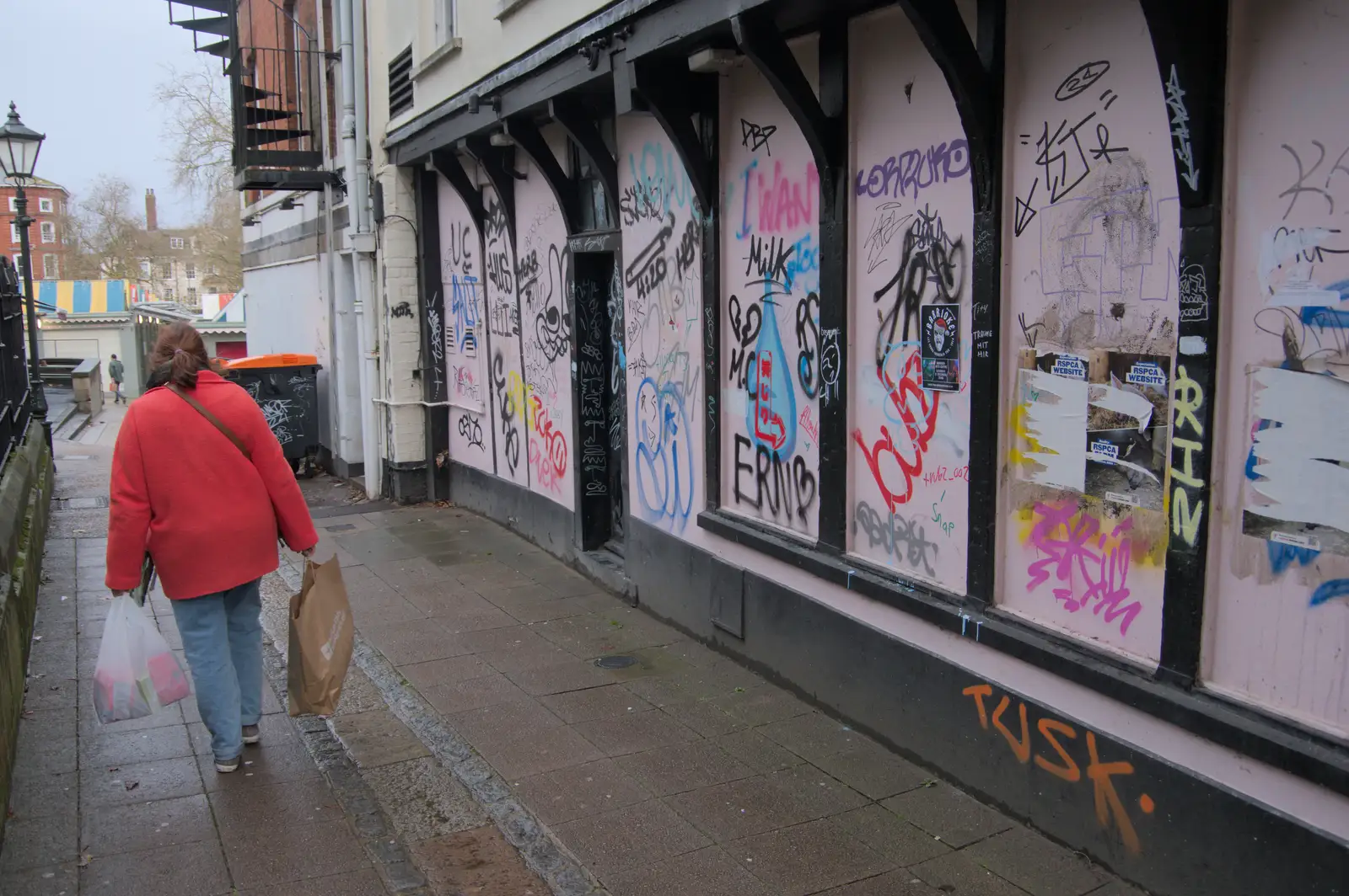 Isobel wanders past a heavily-graffiti'd building, from Christmas Shopping in Norwich, Norfolk - 8th December