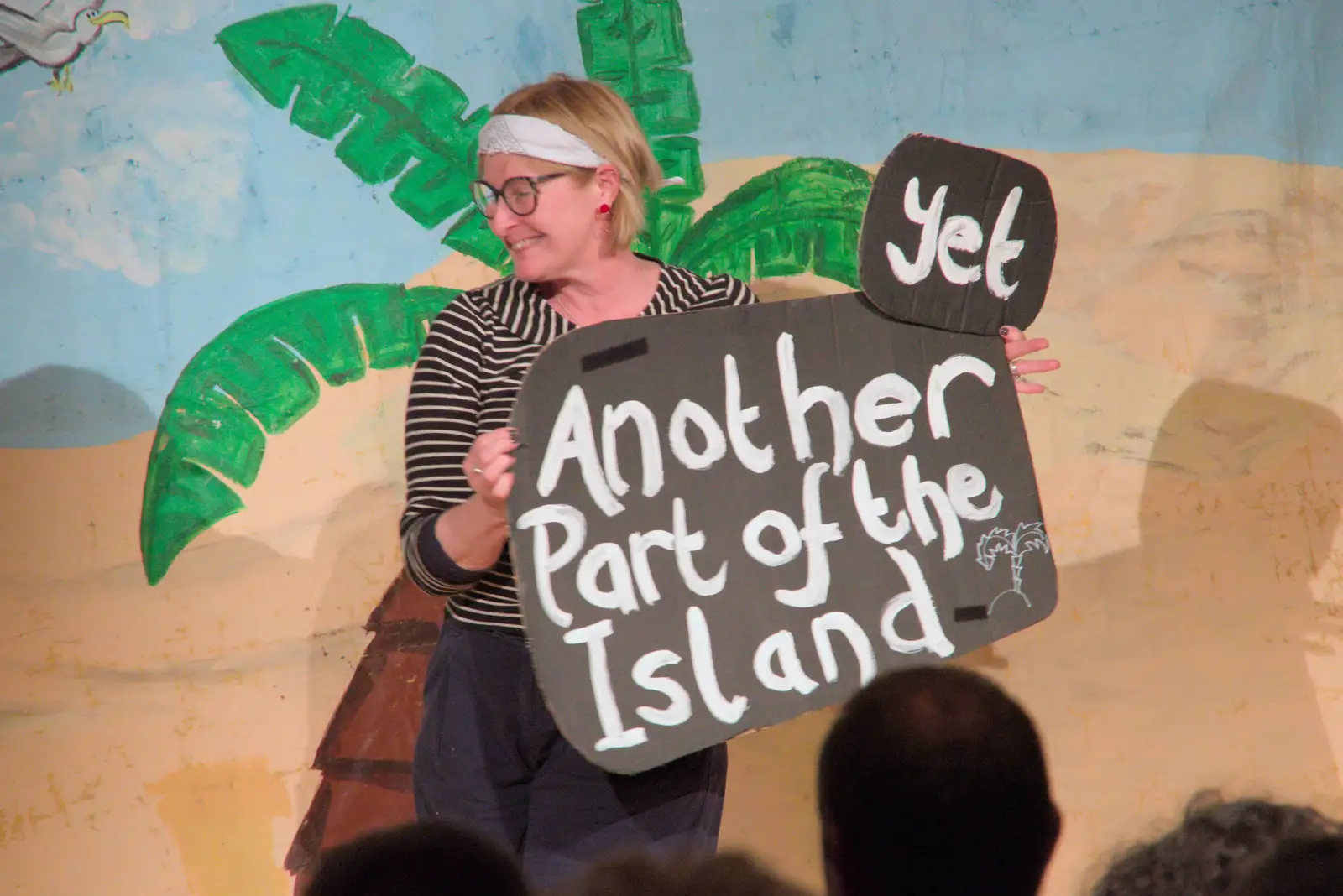 Jo carries a sign across stage, from Dove Players do Treasure Island, The Village Hall, Occold - 11th January 2025