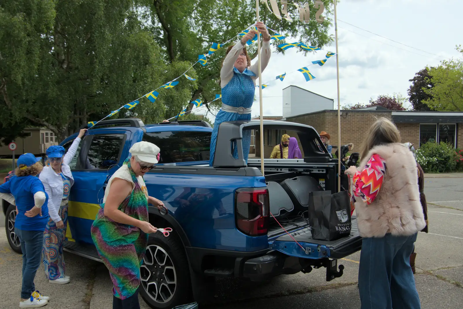 Suzanne wrestles with a string of Swedish flags, from Palgrave Players do the Carnival, Diss, Norfolk - 8th June 2025