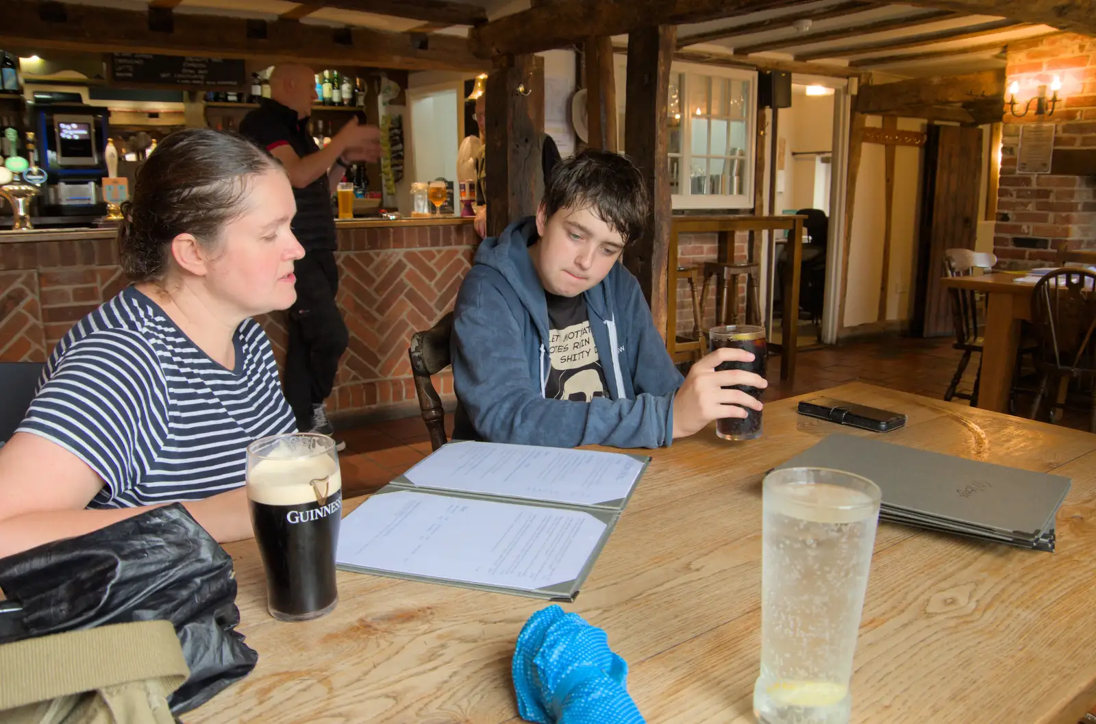 Isobel and Fred scope the menu in the Black Horse, from A Wet Walk to the Black Horse, Thorndon, Suffolk - 20th July 2025