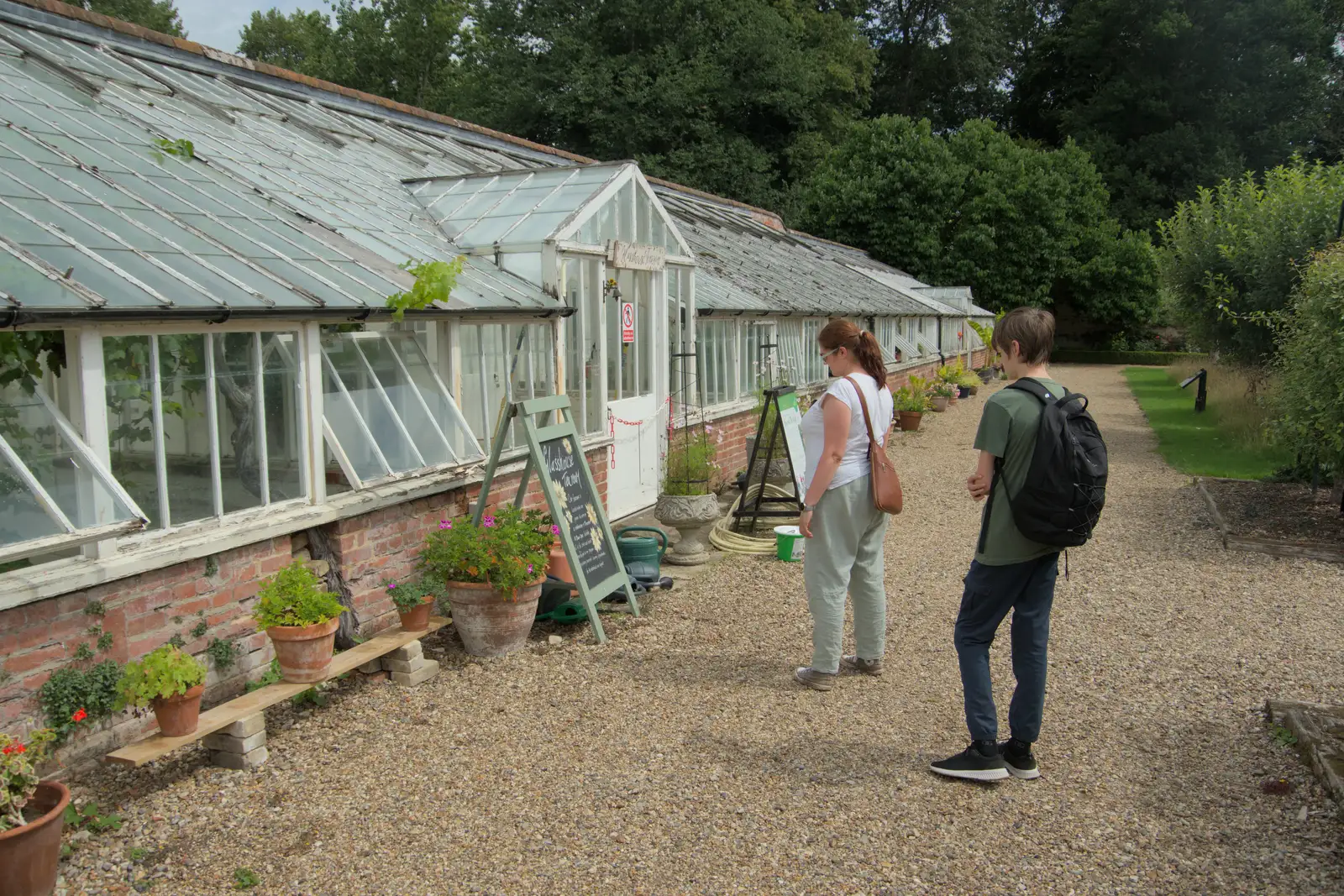 Isobel reads a sign by the decaying glasshouse, from A Visit to the Thornhams, Suffolk - 3rd August 2025