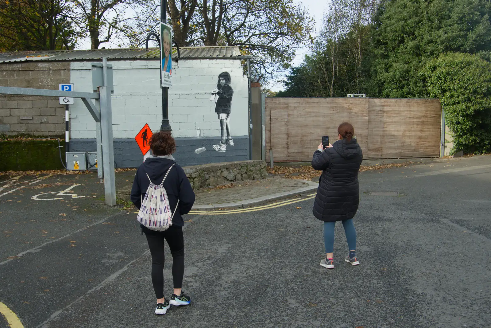 Isobel takes a photo of a Banksy-esque painting, from End of the Line 2: Bré to Blackrock, County Dublin, Ireland - 1st November 2025