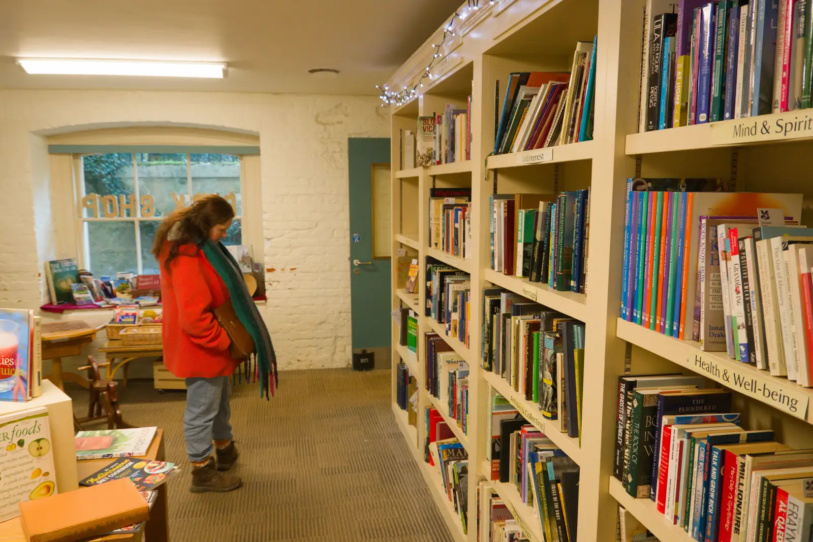 Isobel browses the second hand books in the basement, from Shadow the Snow Leopard at Ickworth House, Horringer - 4th January 2026