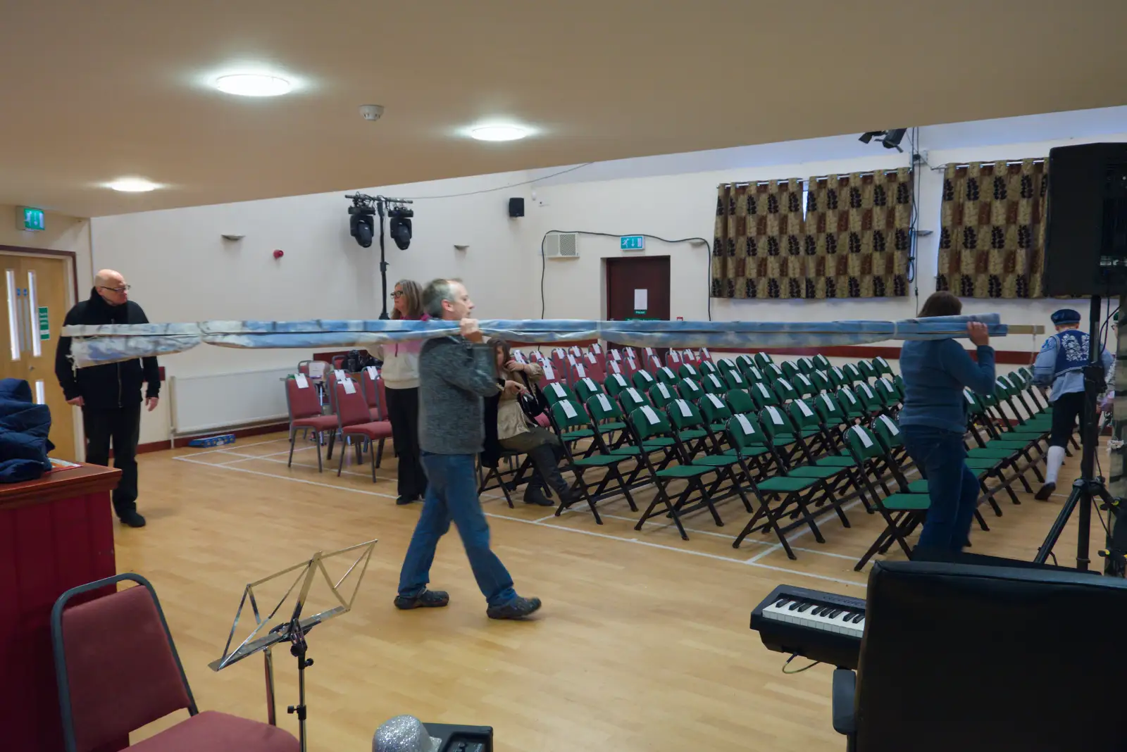 The backdrop is carried to the stage, from Dove Players' Pantomime, and Lunch in the Lion, Debenham - 11th January 2026