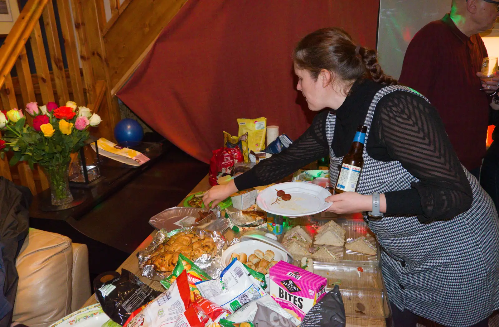 Isobel reaches over for some party scran, from Dove Players' Wrap Party, Braisworth, Suffolk - 23rd JAnuary 2026