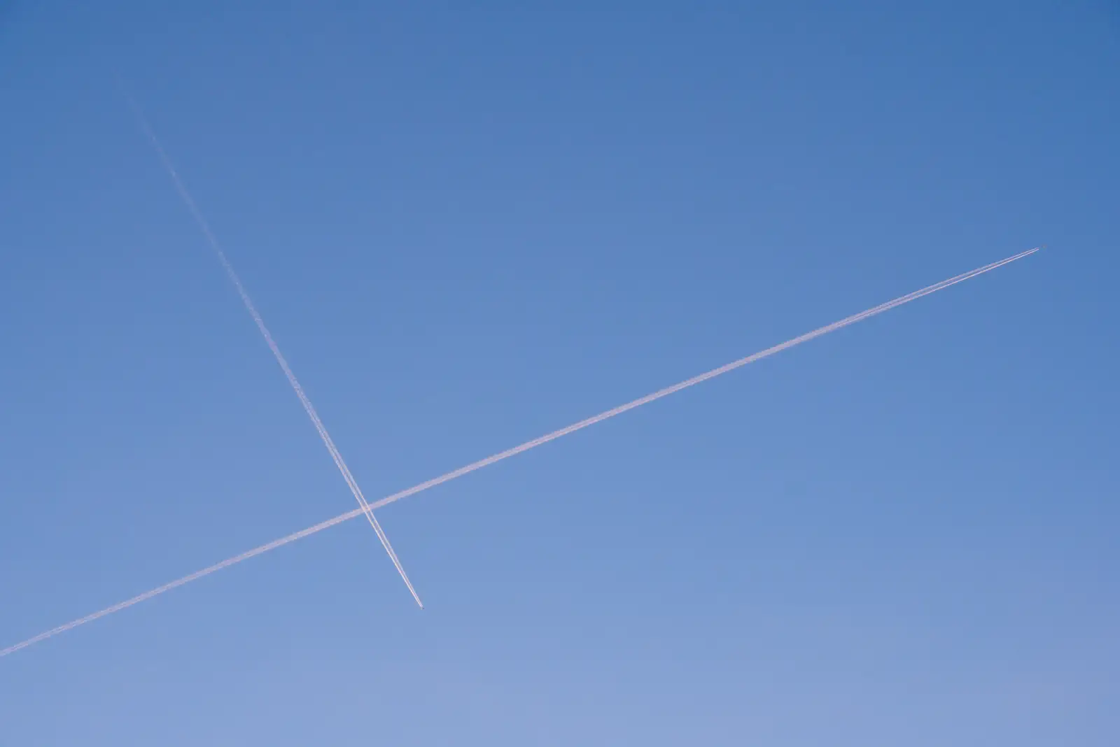 Two contrails cross in the sky, from Saxophone Shopping in Cambridge - 21st March 2026