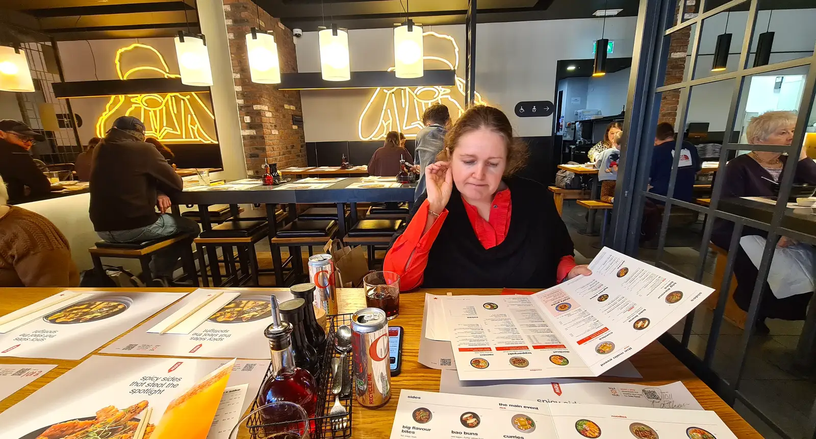 Isobel scopes out the menu in Wagamama, from Hospital Trips to Norwich, Norfolk - 25th March 2026