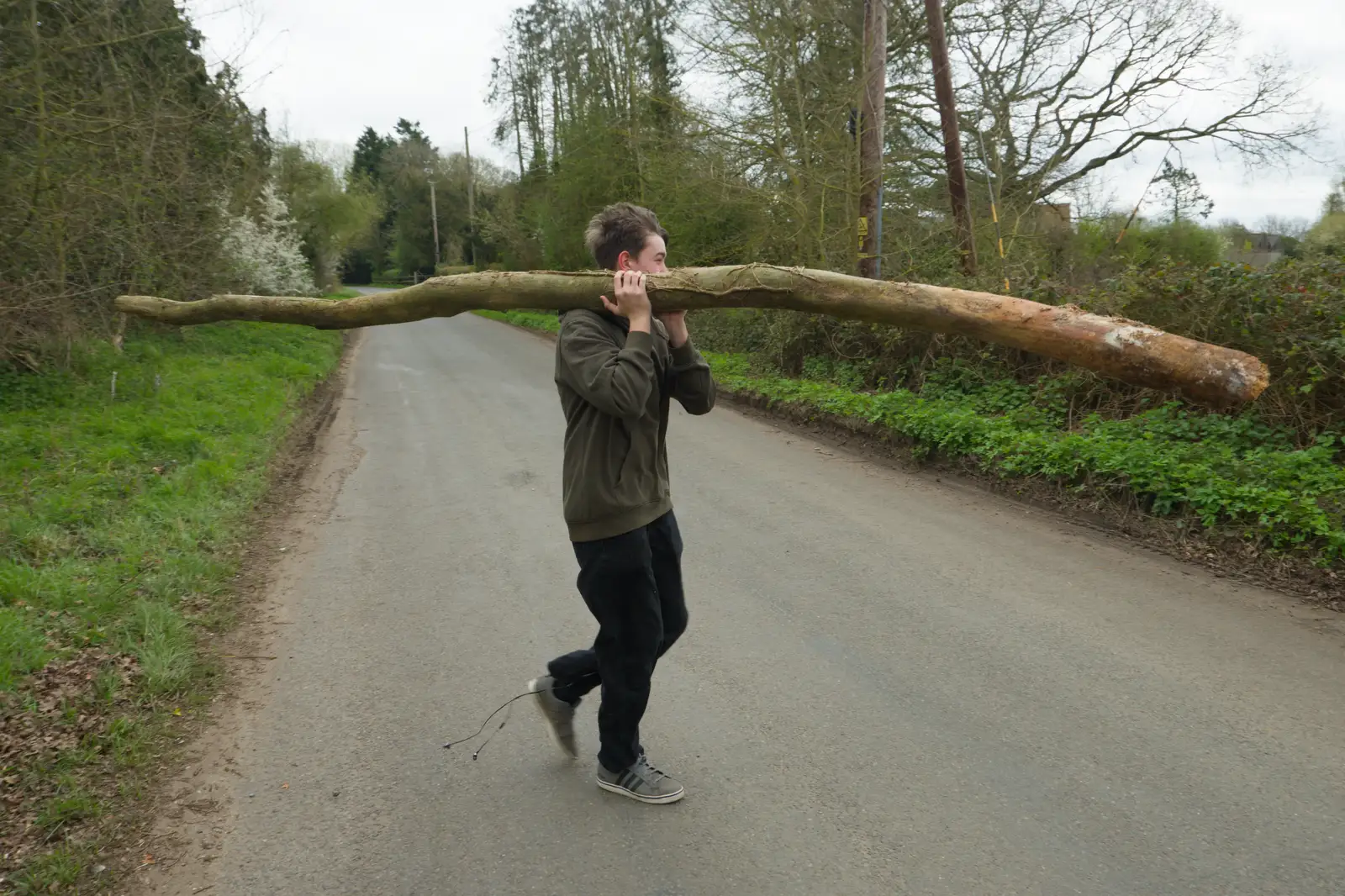 Fred carries his log across Rectory Road, from Walking Around, and Fred's Log, Brome, Suffolk - 3rd April 2026