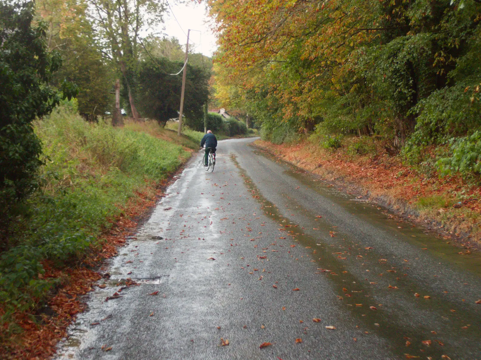 Mick heads off up the hill out of Thornham, from A Wet Ride to the Four Horseshoes, Thornham - 19th August 2026