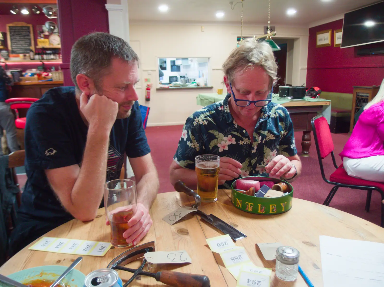 One of the quiz-setters brings over a tin of stuff, from A Village Hall Quiz and a Dead Pub, Worlingworth - 21st August 2026