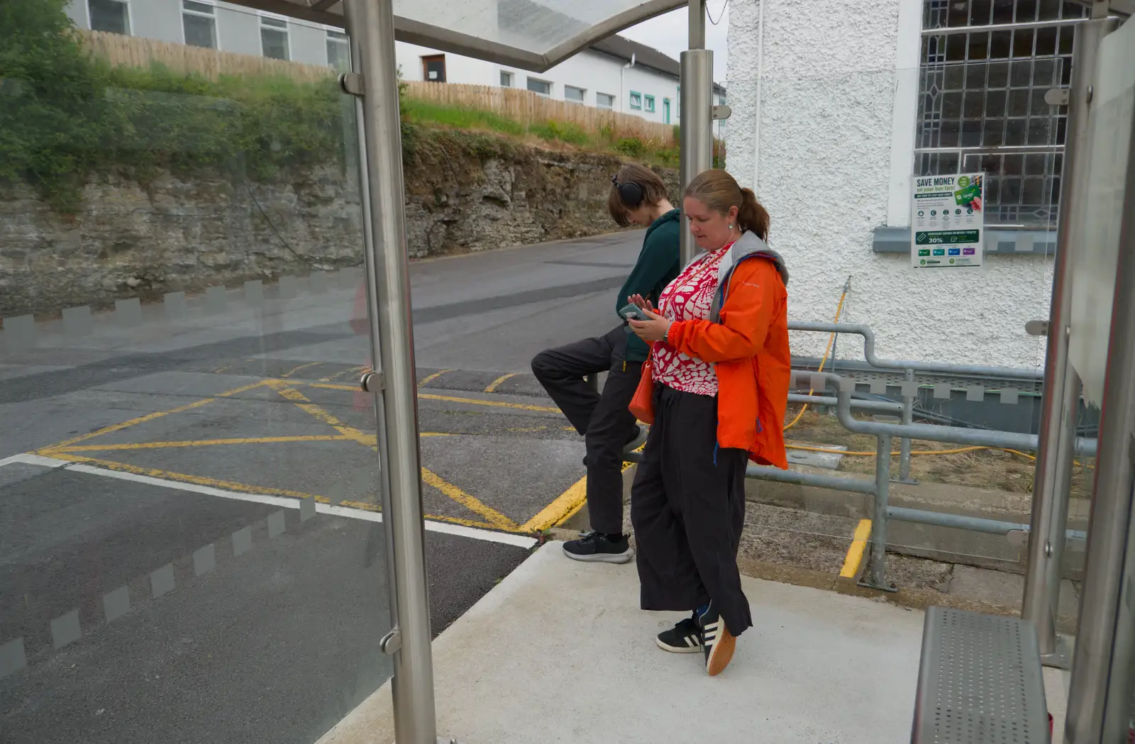 Isobel checks her phone at the bus stop, from Manorhamilton, Sligo and Streedagh Beach, Leitrim, Ireland - 26th August 2026