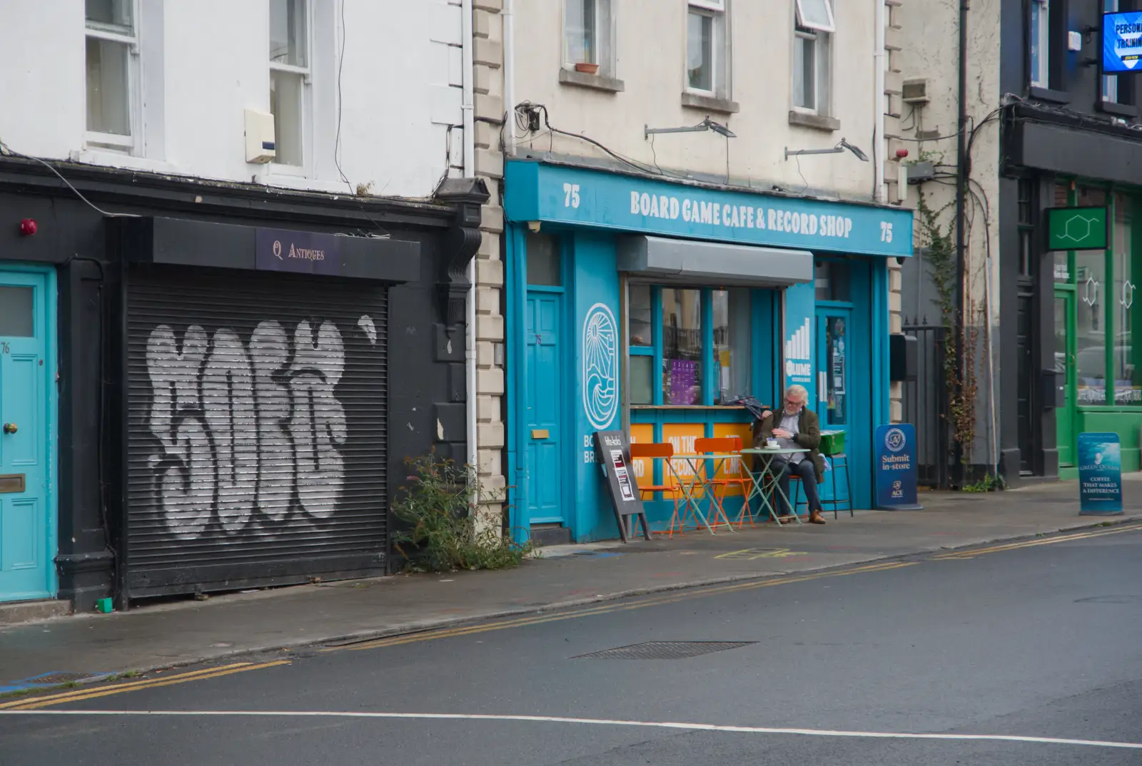 A dude has a coffe outside the Boardgame Café, from Castle Dargan Golf, Glangelvin and Pizza in Dún Laoghaire, Ireland - 28th August 2026